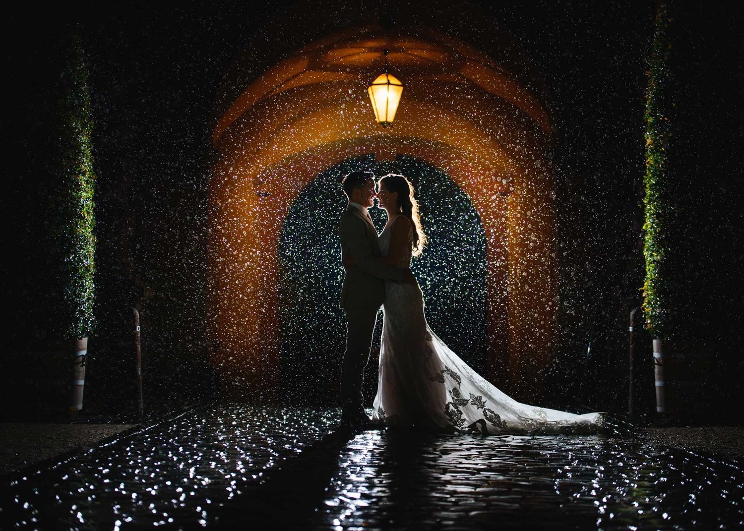 Couple silhouetted in a lantern-lit tunnel