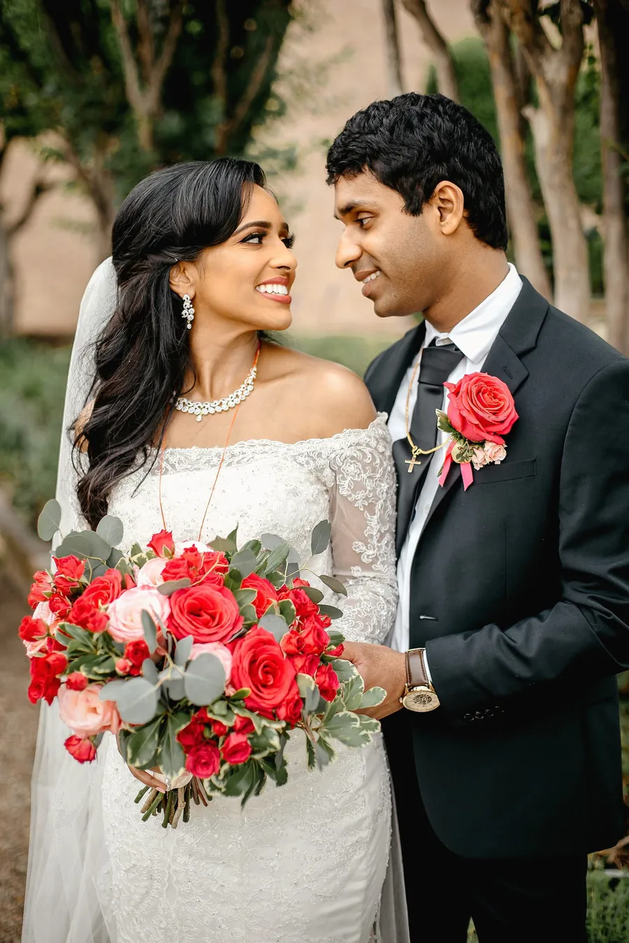 Bride and groom kissing at golden hour with a flowing veil