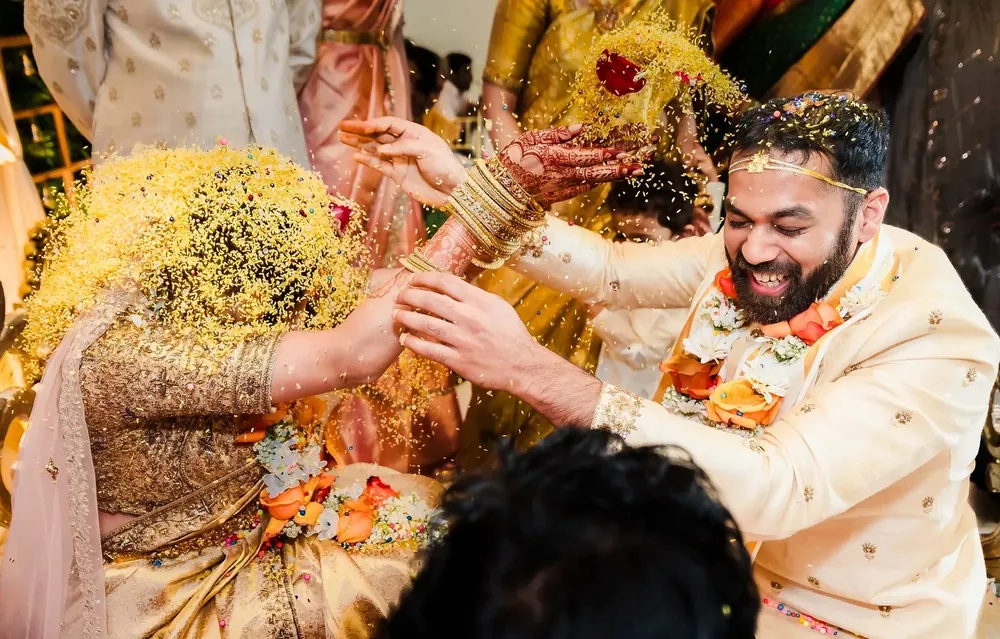 Bride and groom smiling at each other among greenery